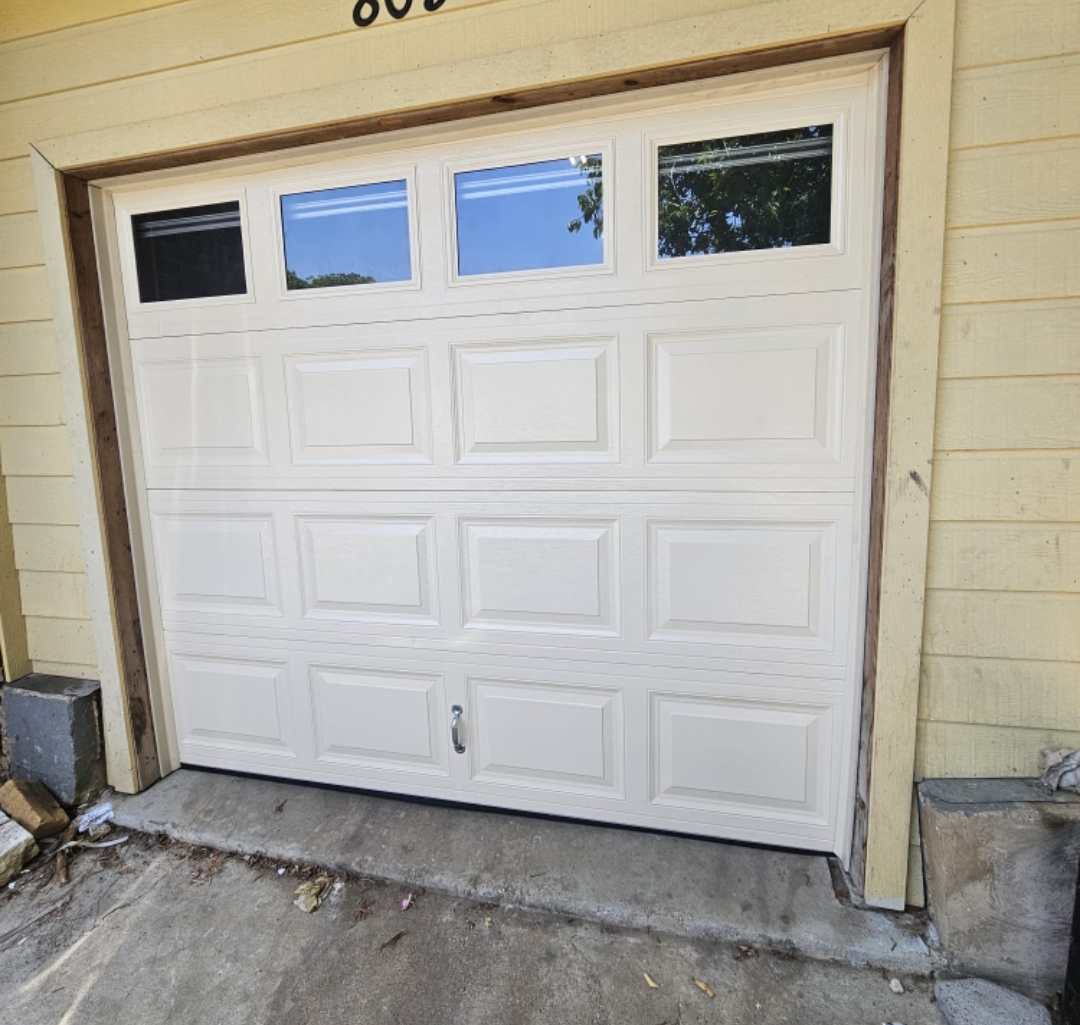 White 8x7 raised-panel garage door with a row of windows across the top section